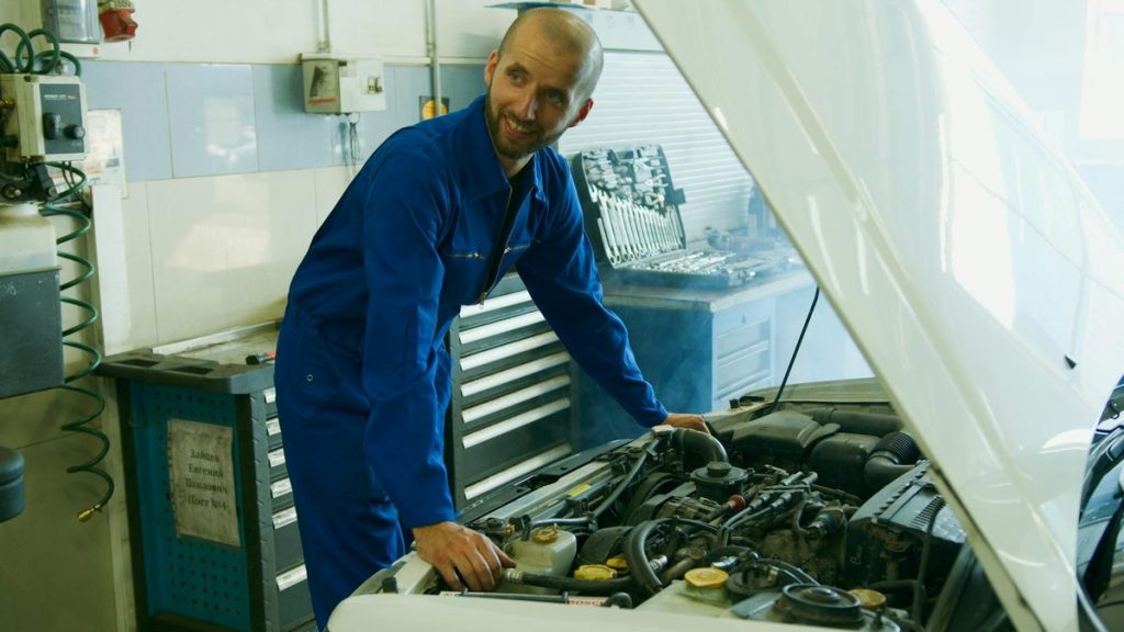 A trusted team of certified auto repair technicians standing confidently together in a professional workshop